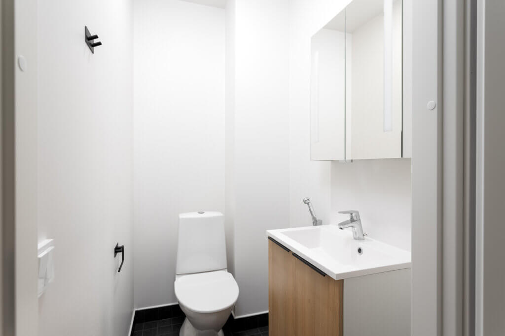 Paritaloasunnon yläkerran wc puun värisillä kalusteilla